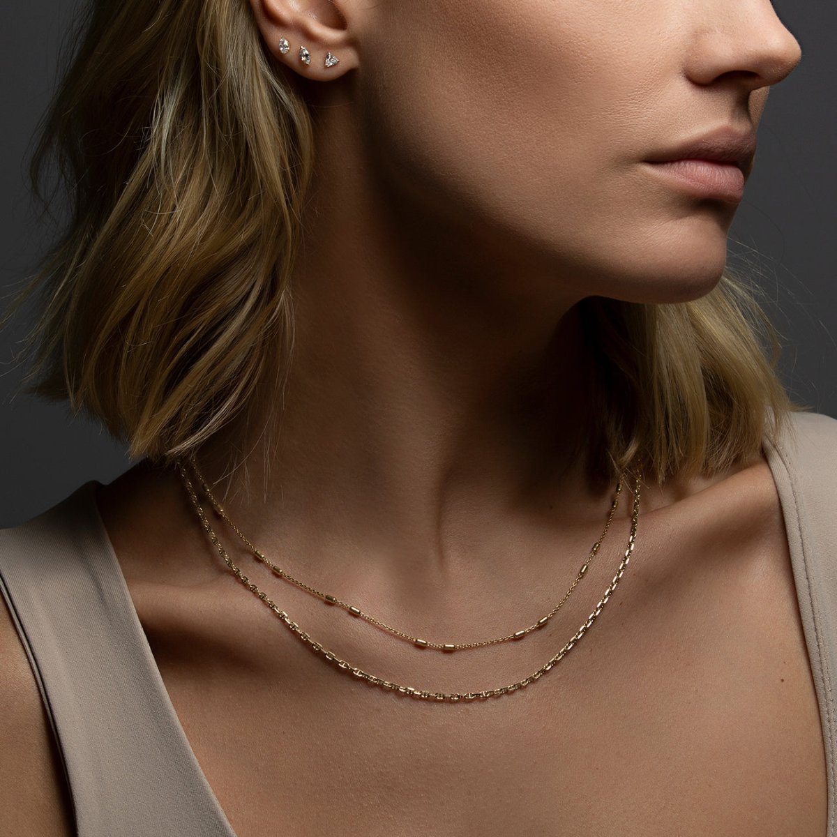 Gold vermeil bar-station chain choker shown layered on a model's neckline