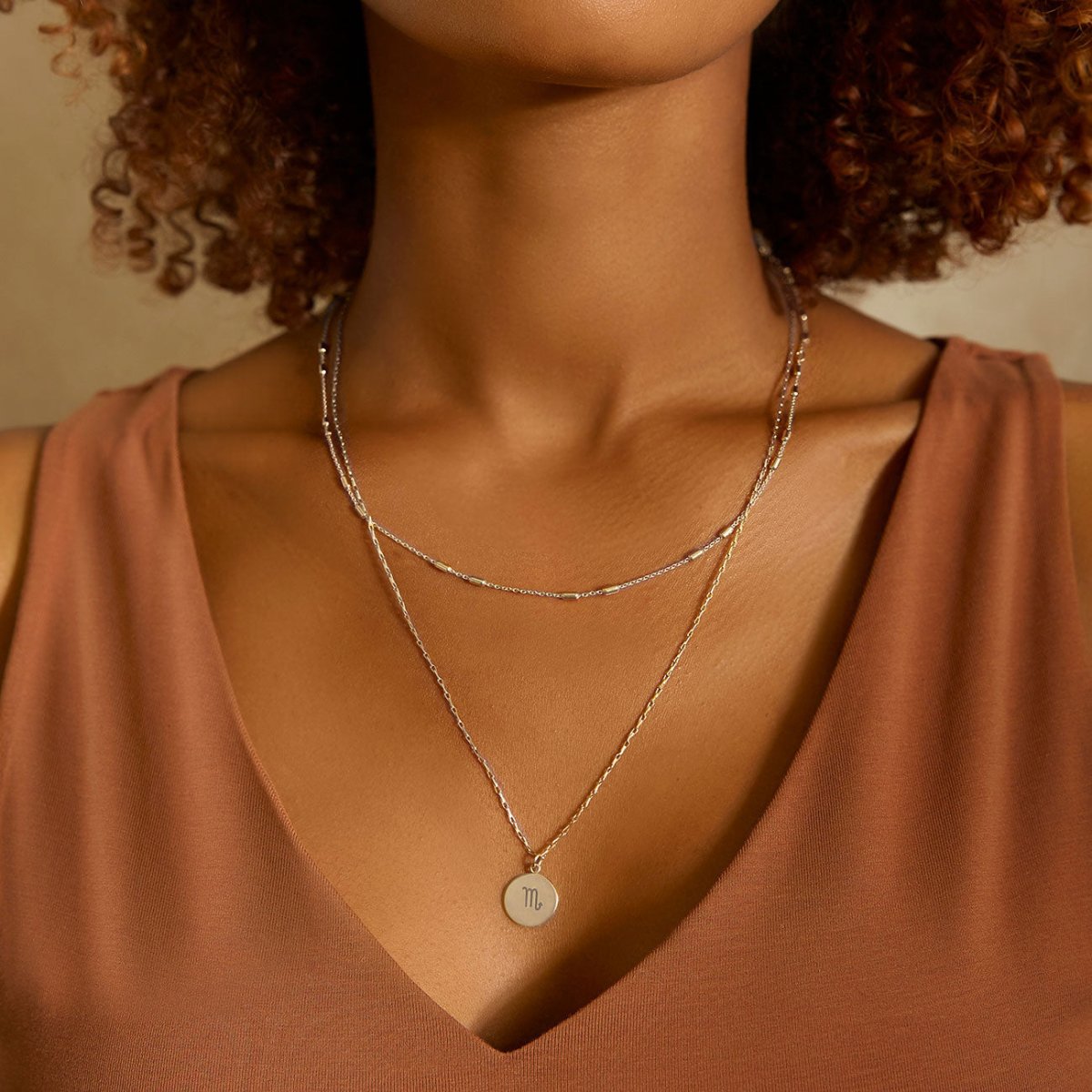 Sterling silver layered chain choker with a round disc pendant, shown on a model's neckline
