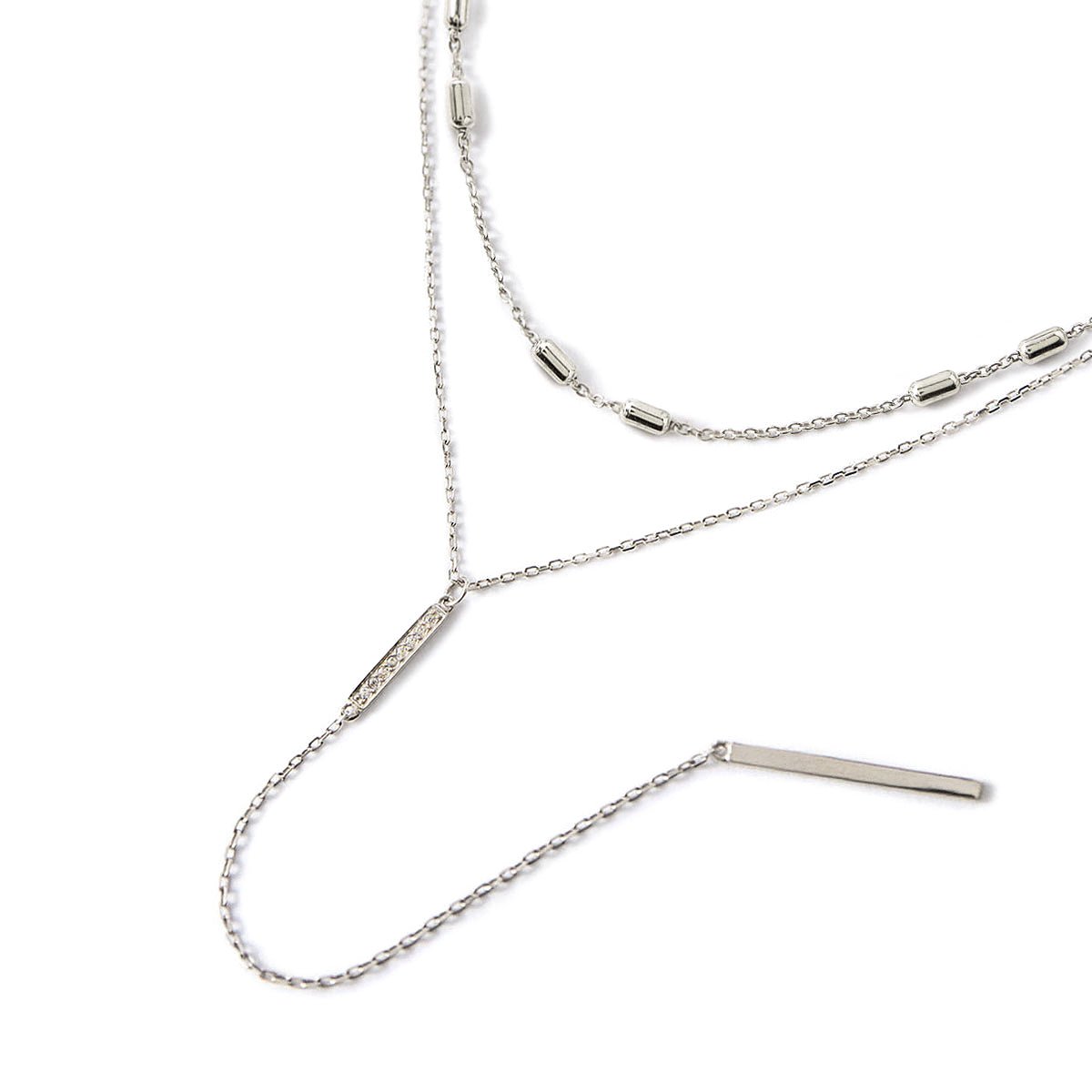 Sterling silver choker and lariat duo with a pave bar set with clear stones, on a white background