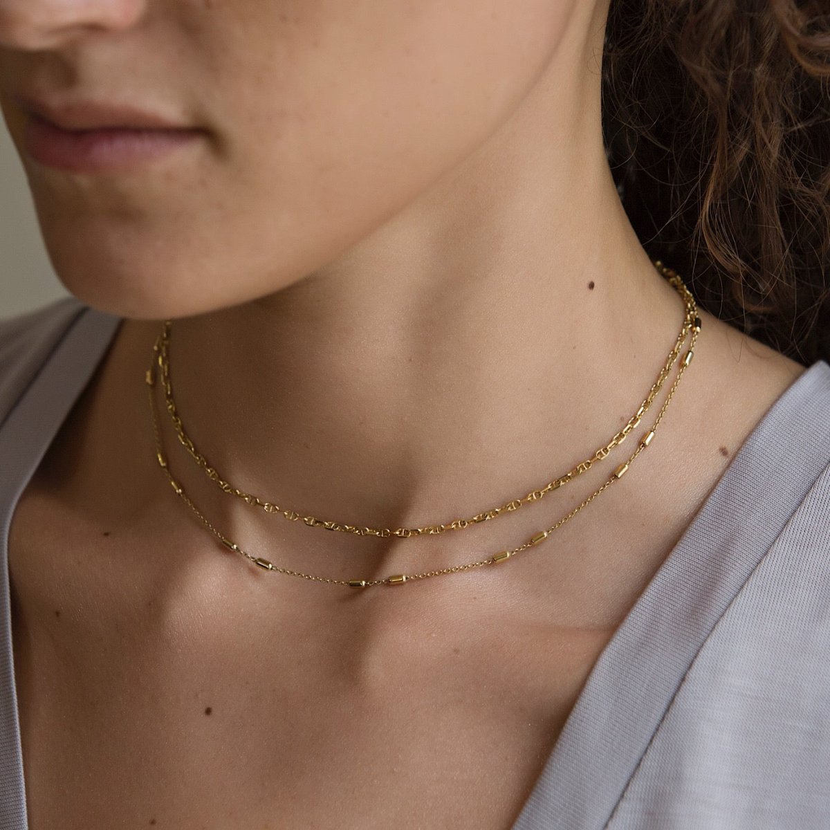 Gold vermeil double-strand choker with patterned and beaded chains, shown on a model's neck