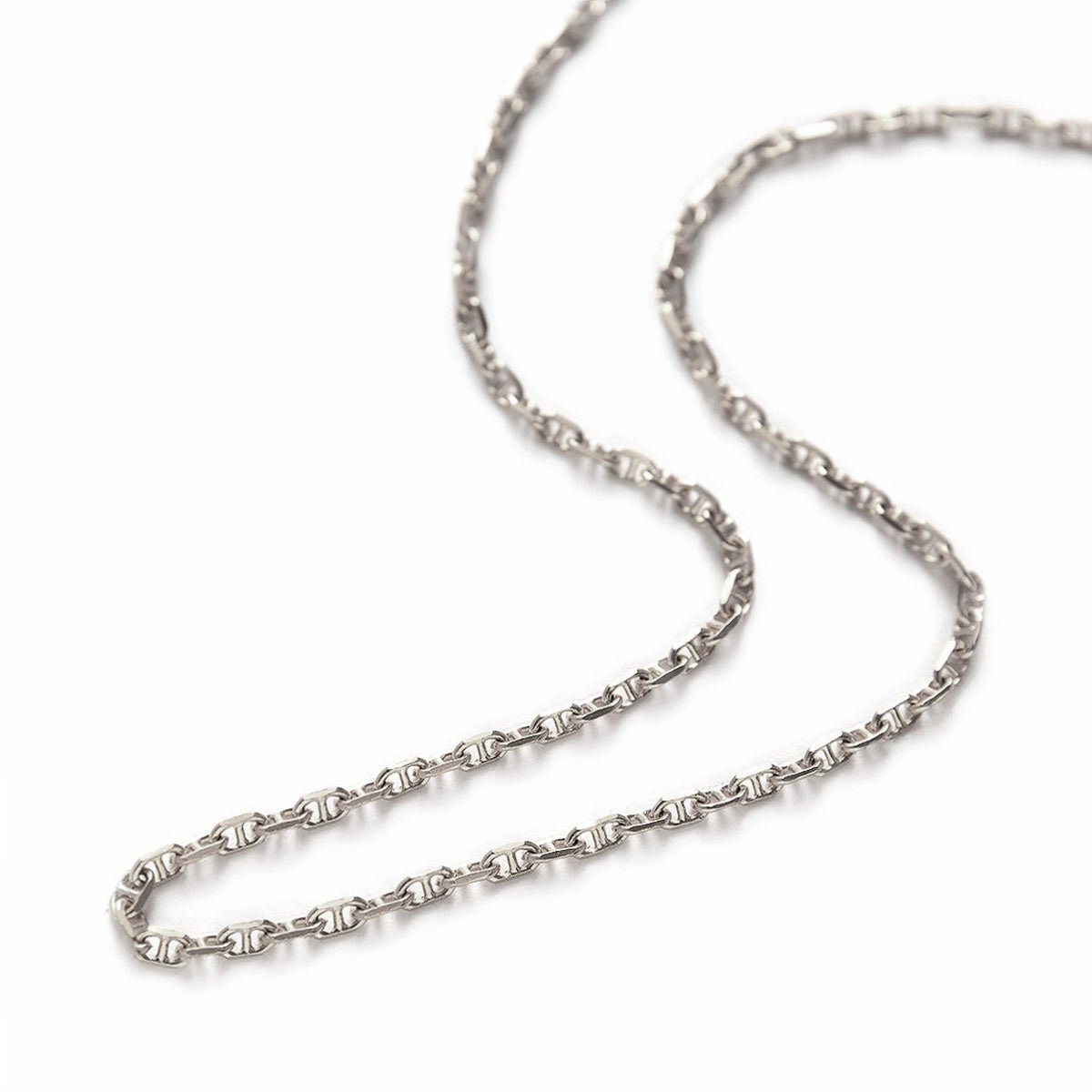 Sterling silver Marina chain choker laid in an open curve, close-up detail of the links