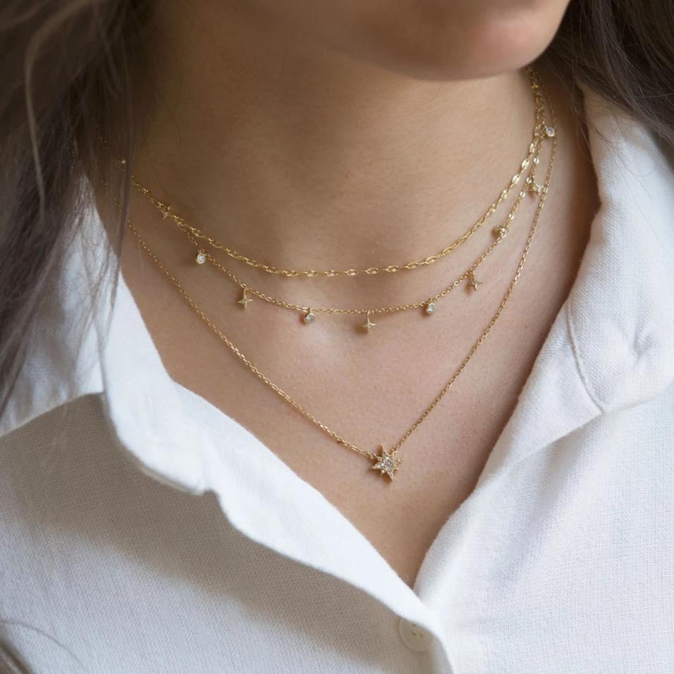 Gold vermeil layered trio of star and zirconia drop chains with a pavé star pendant, shown on a model's neckline