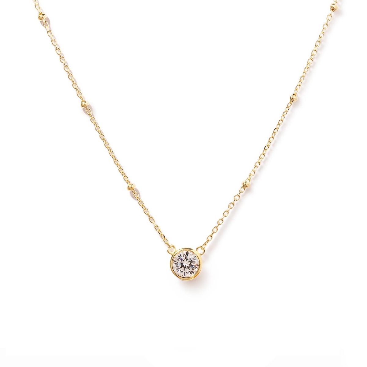 Gold vermeil pendant necklace with a round clear stone on a beaded chain, on a white background
