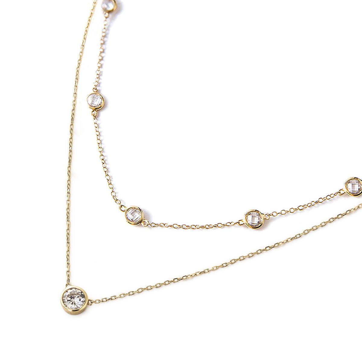 Gold vermeil station chain and solitaire pendant duo with clear stones, on a white background