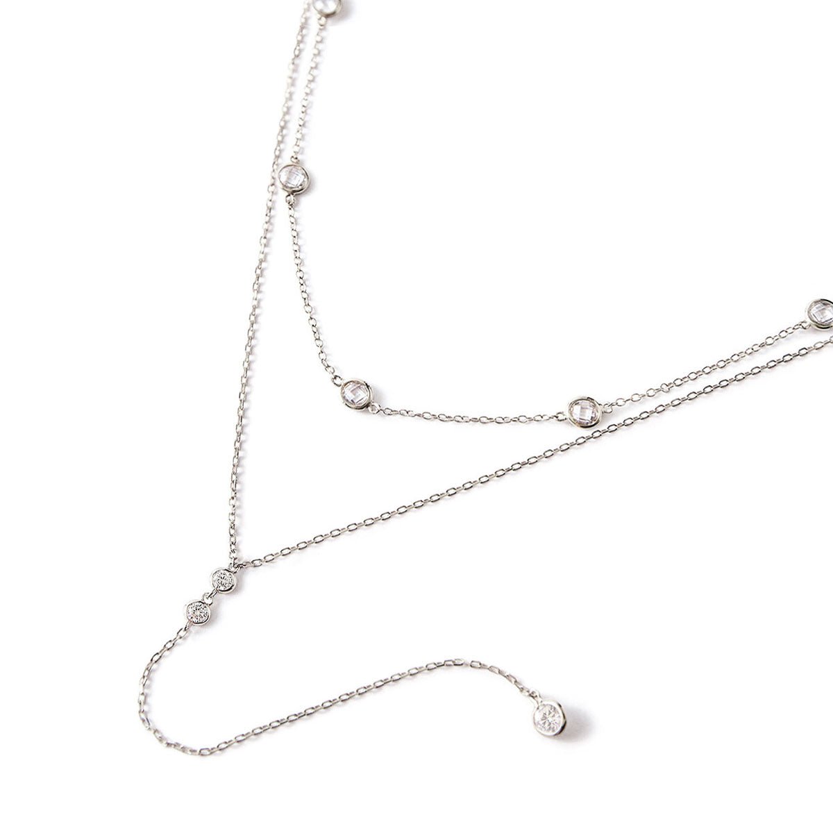 Sterling silver layered choker and lariat duo with white zirconia stations, laid on a white background