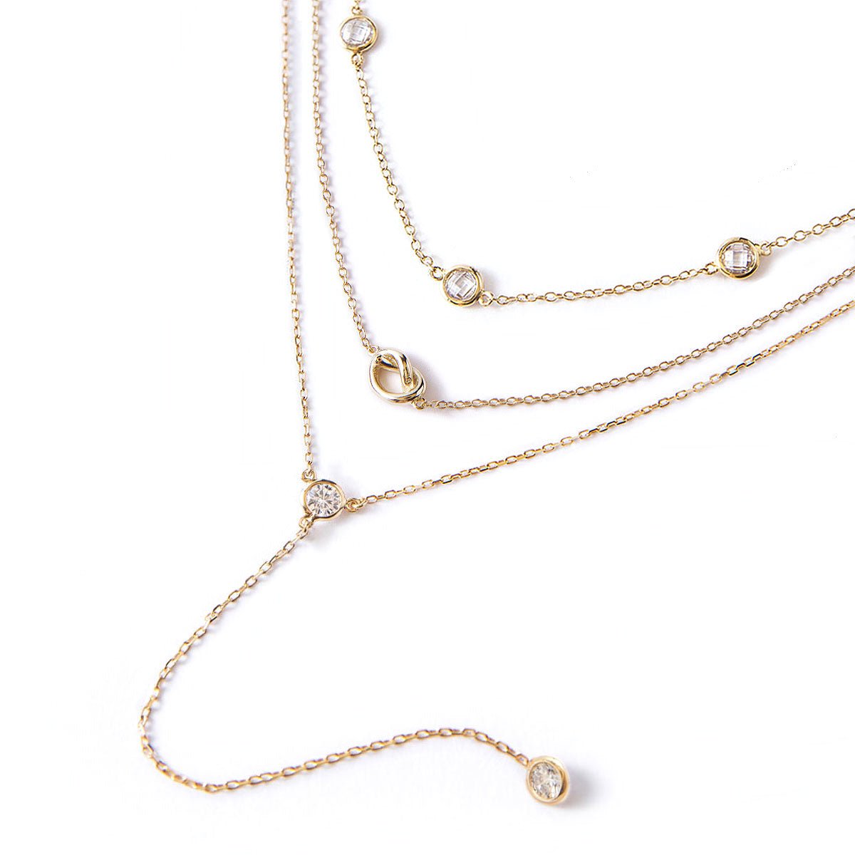 Gold vermeil layered lariat trio with a knot and bezel-set clear white zirconia, on a white background