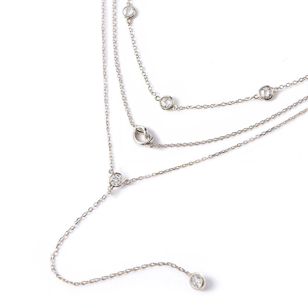 Sterling silver layered lariat trio with a knot and bezel-set clear white zirconia, on a white background