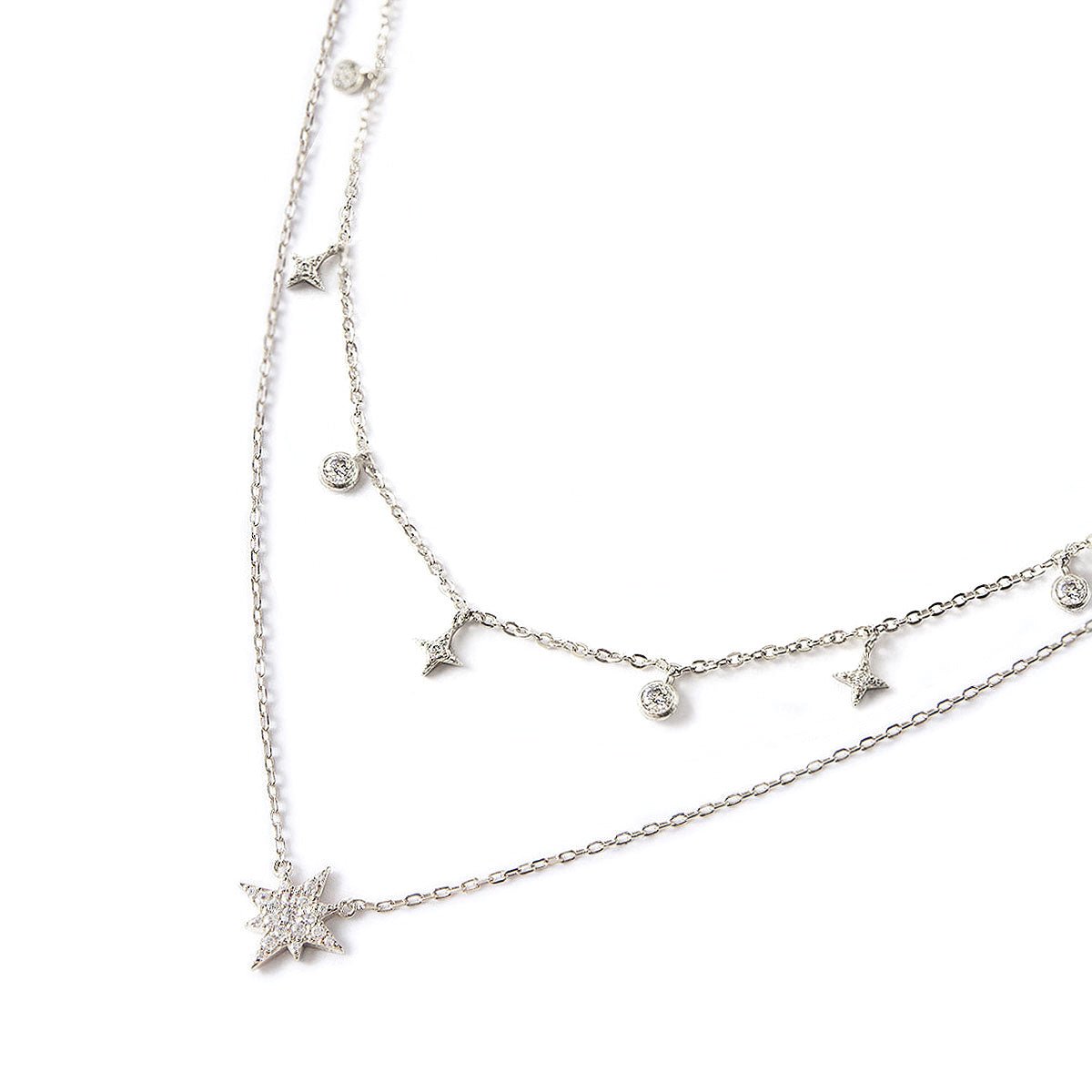 Sterling silver layered duo of a star and zirconia drop chain and a pavé star pendant chain, on a white background