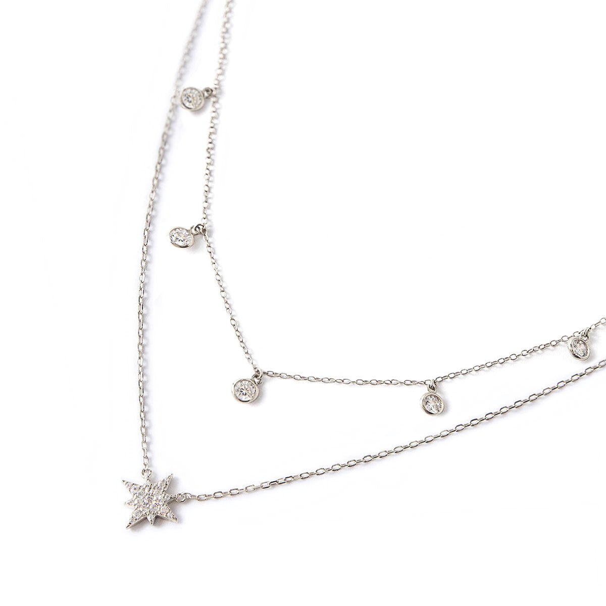 Sterling silver layered choker duo, starburst pendant and clear bezel station chain, on a white background