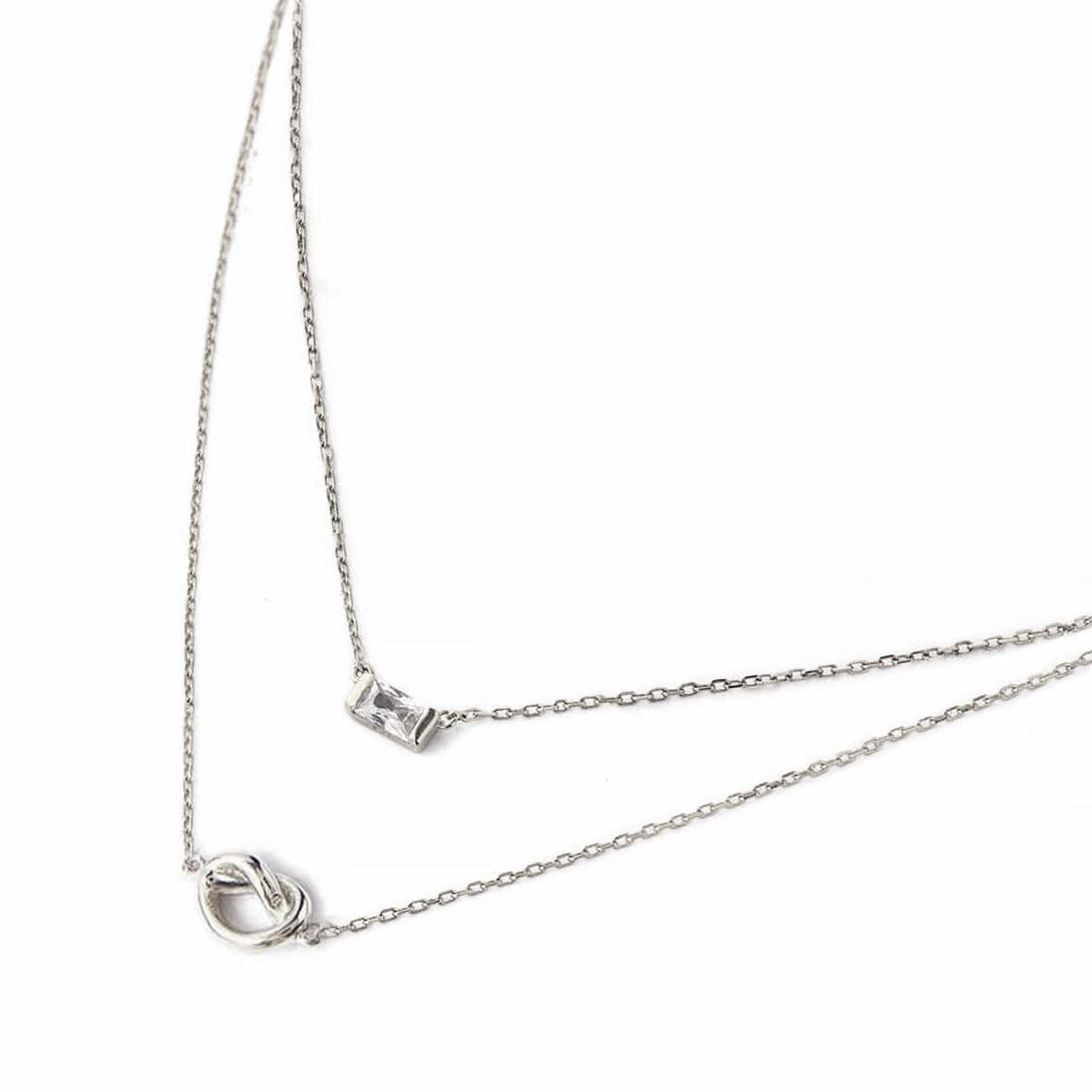 Sterling silver baguette white zirconia pendant and loveknot necklace duo, close-up on a white background