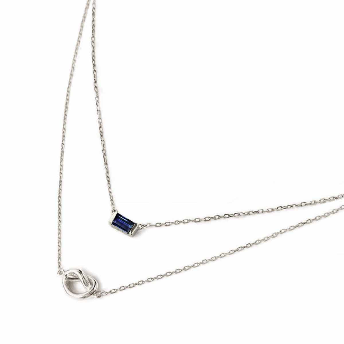Sterling silver layered duo necklace with a blue baguette stone and a knot, on a white background