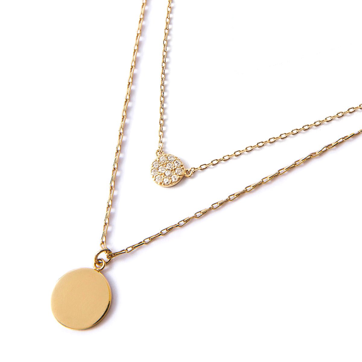 Gold vermeil layered necklace duo with a plain disc and a round zirconia pavé disc, on a white background