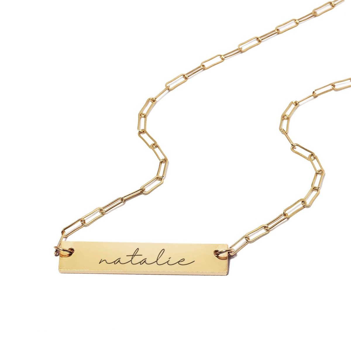 Gold-filled engravable bar necklace on a paperclip chain, bar engraved with a name, on a white background