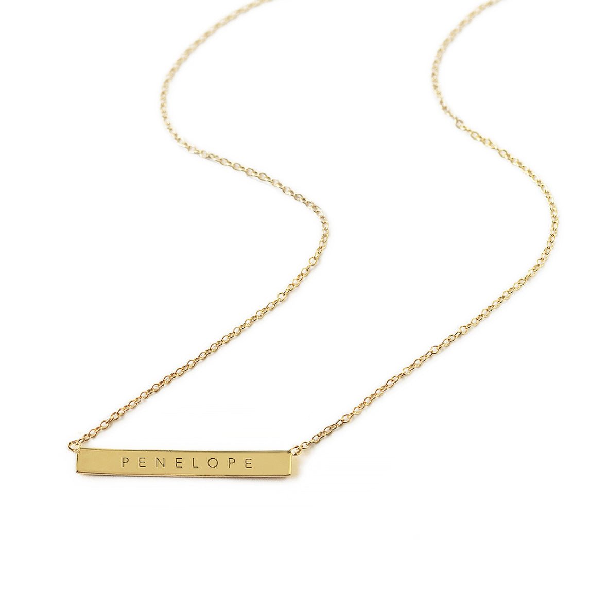 Gold vermeil bar necklace engraved with a name on a thin cable chain, on a white background