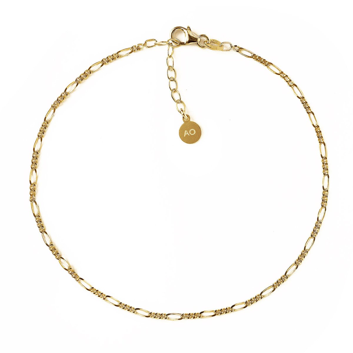 Gold vermeil Figaro chain anklet with a lobster clasp and round logo tag, on a white background