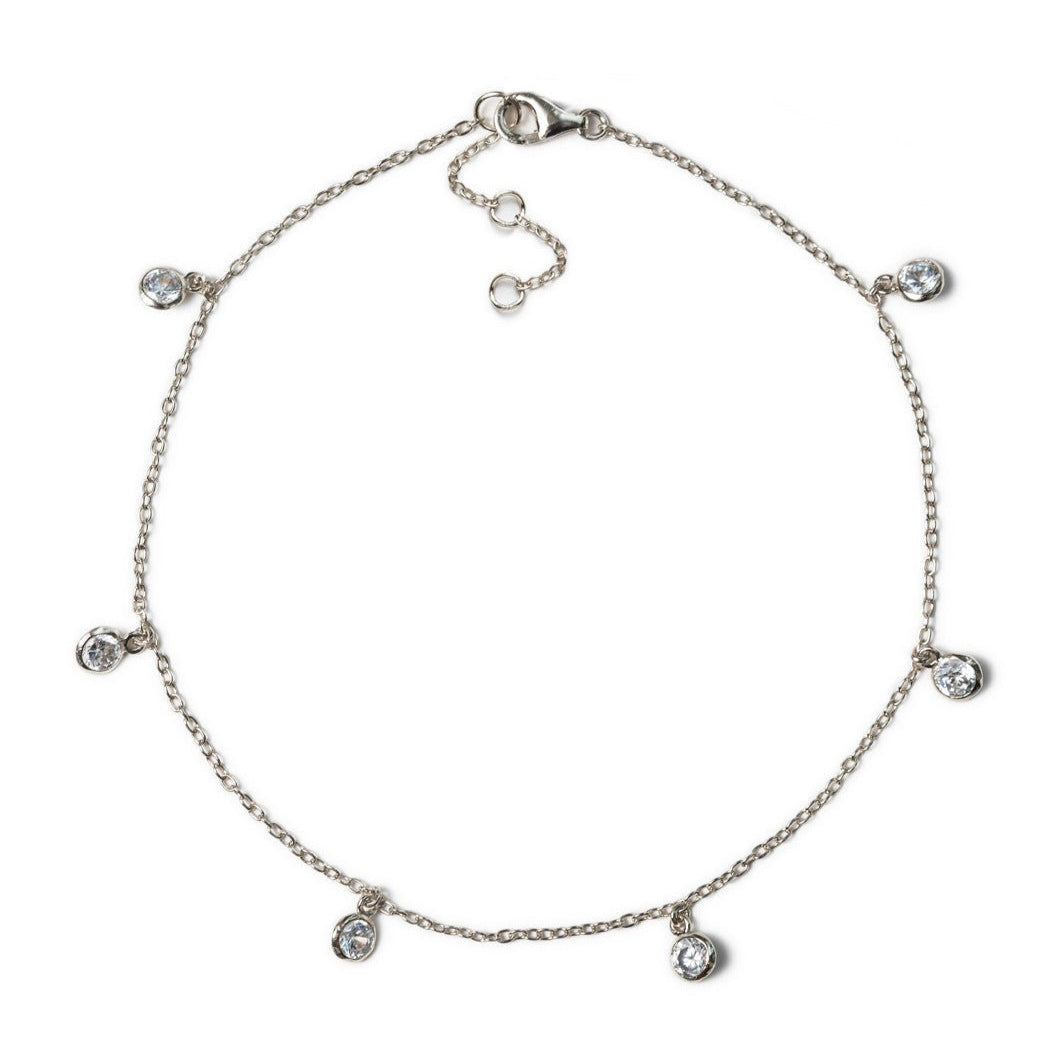 Sterling silver anklet with six dangling round bezel-set clear stones, on a white background