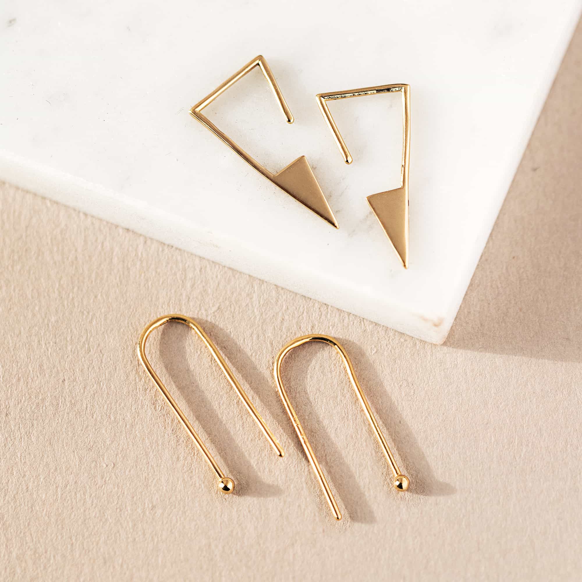 14K gold open triangle threader earring with a pointed drop, shown on a model's lobe
