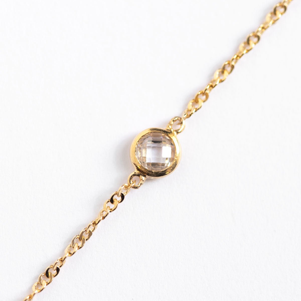 Gold vermeil Singapore chain bracelet, close-up detail of the round faceted clear bezel stone