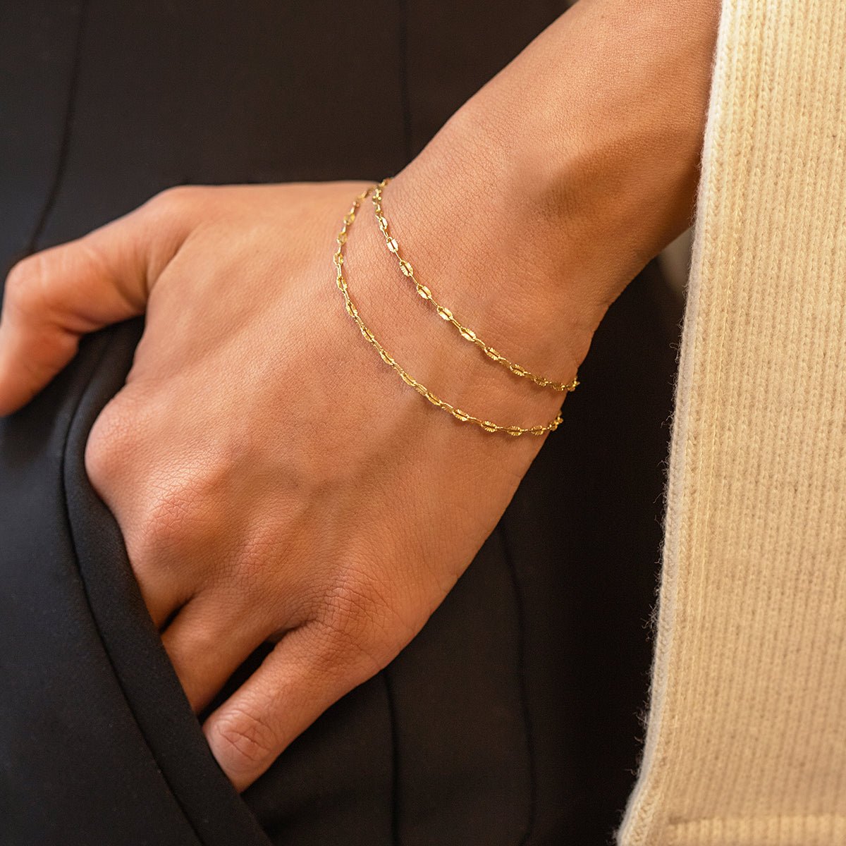 Gold vermeil lace chain wrapped twice around a model's wrist, close-up detail