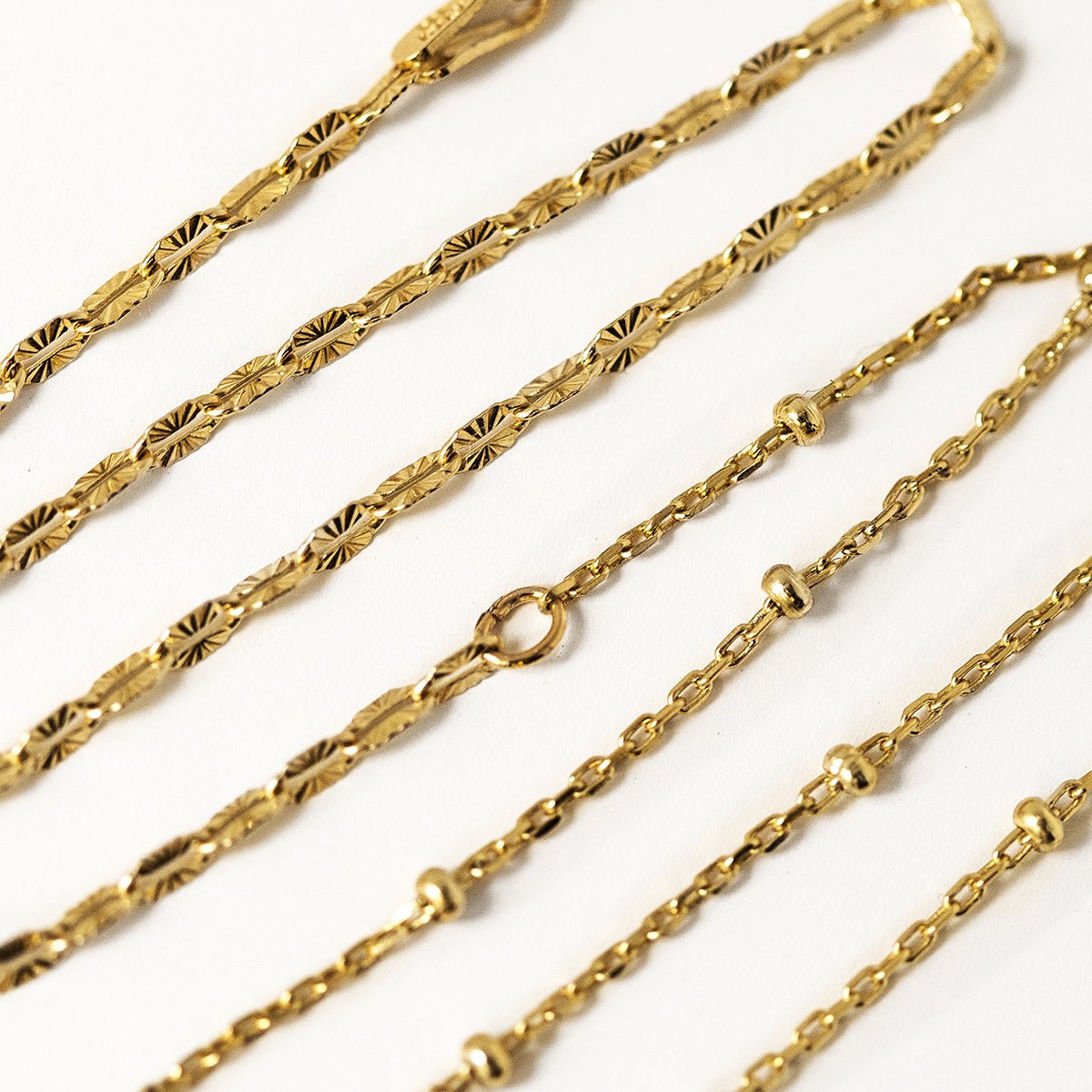 Gold vermeil double layered chain bracelet, close-up detail of the textured and satellite chains