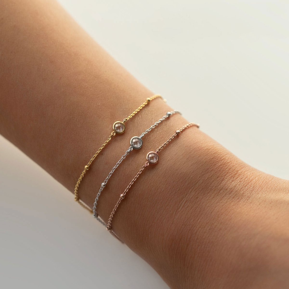 Gold vermeil crystal satellite chain bracelet shown stacked on a model's wrist