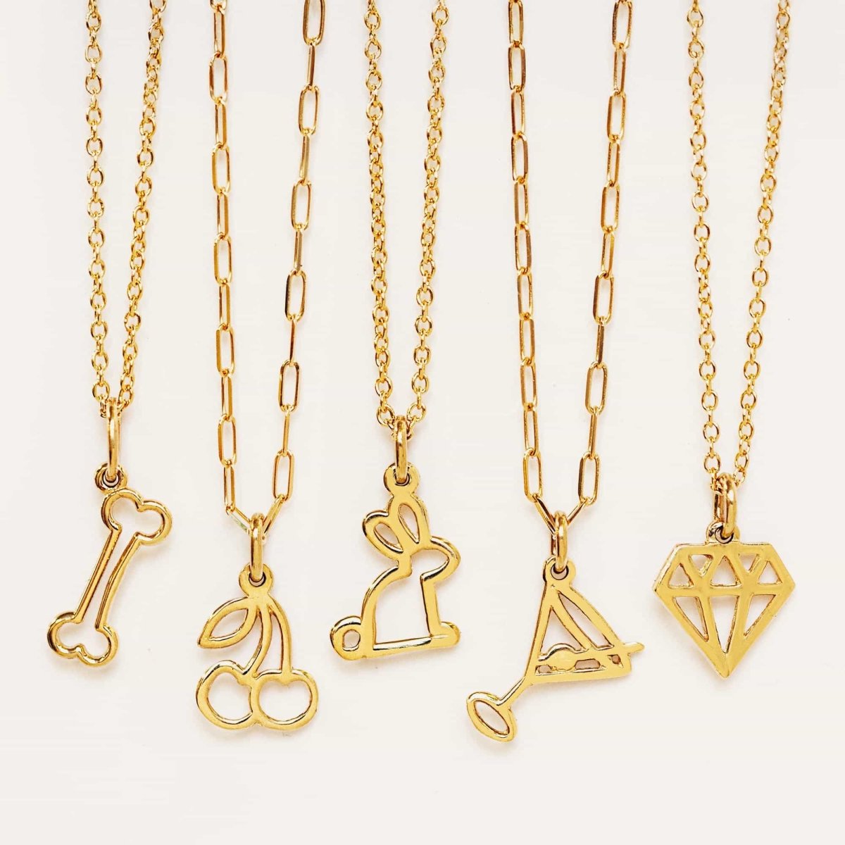 14K gold rabbit outline charm necklace shown in a row of outline charm necklaces, on a white background