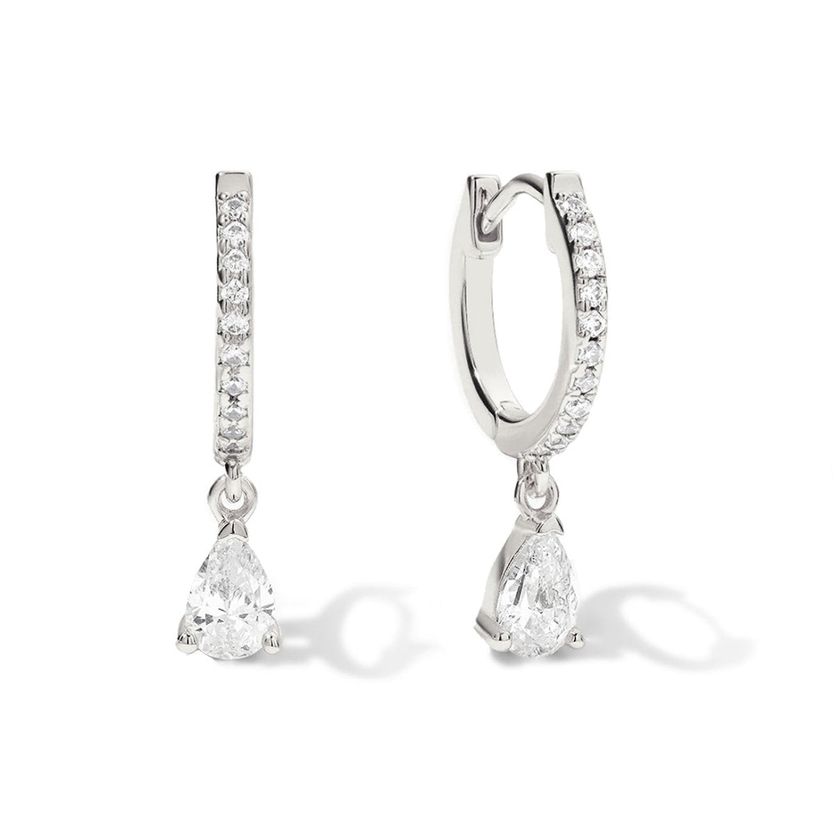 Sterling silver pavé huggie hoops with pear-shaped clear zirconia drops, on a white background
