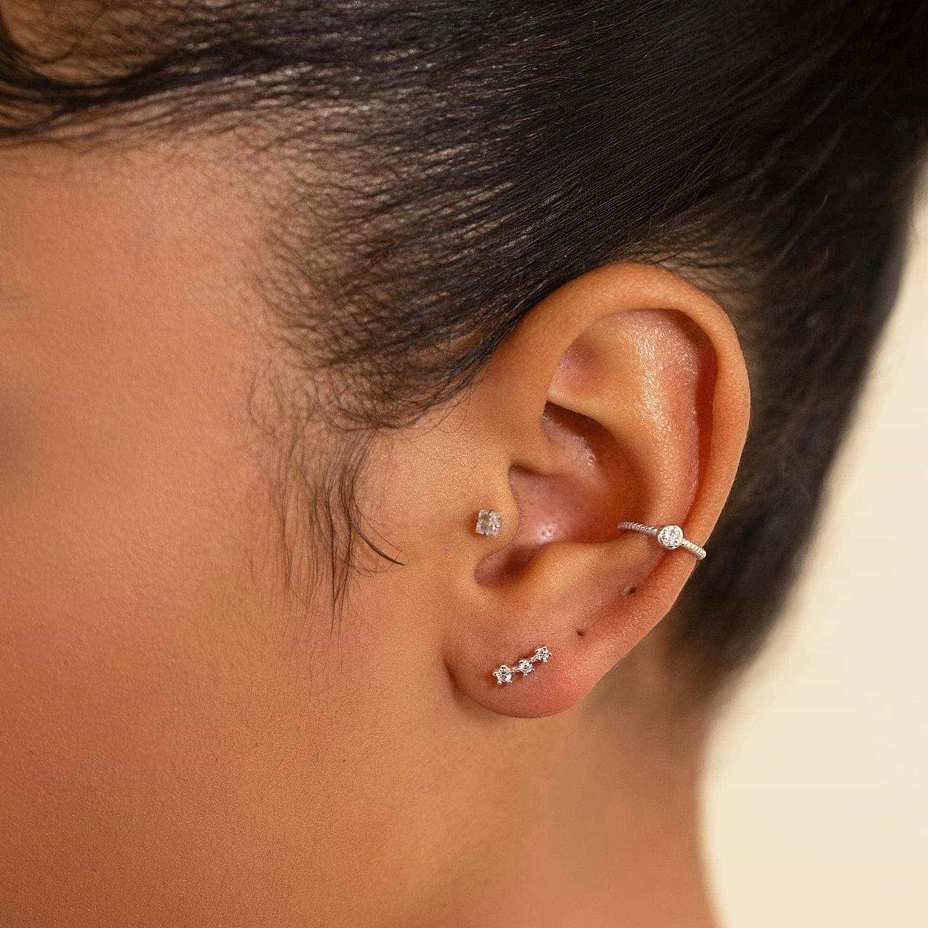 Silver twisted-rope ear cuff with a clear stone, shown on a model's upper ear