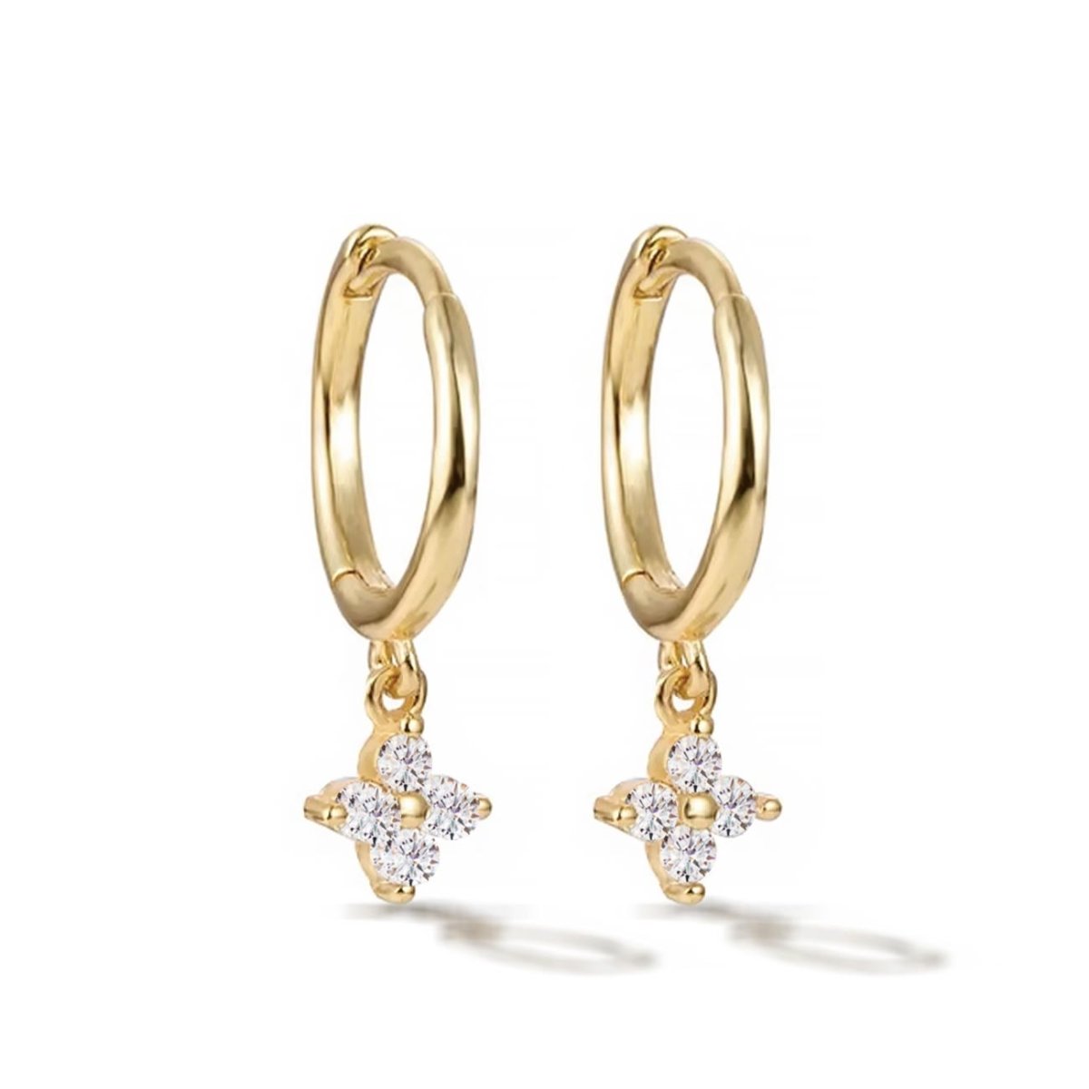 Pair of gold vermeil Flor huggie hoops with a clear white zirconia flower, on a white background