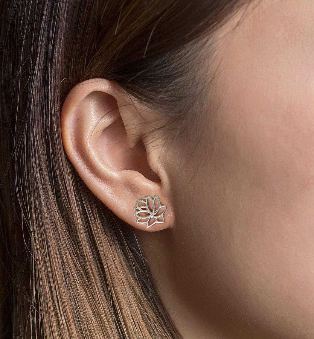 Sterling silver lotus flower stud earring shown on a model's earlobe