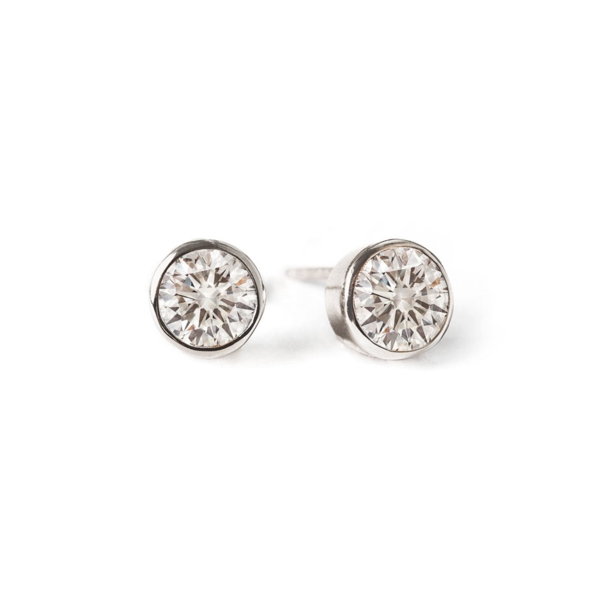 Pair of sterling silver bezel-set white zirconia stud earrings, on a white background