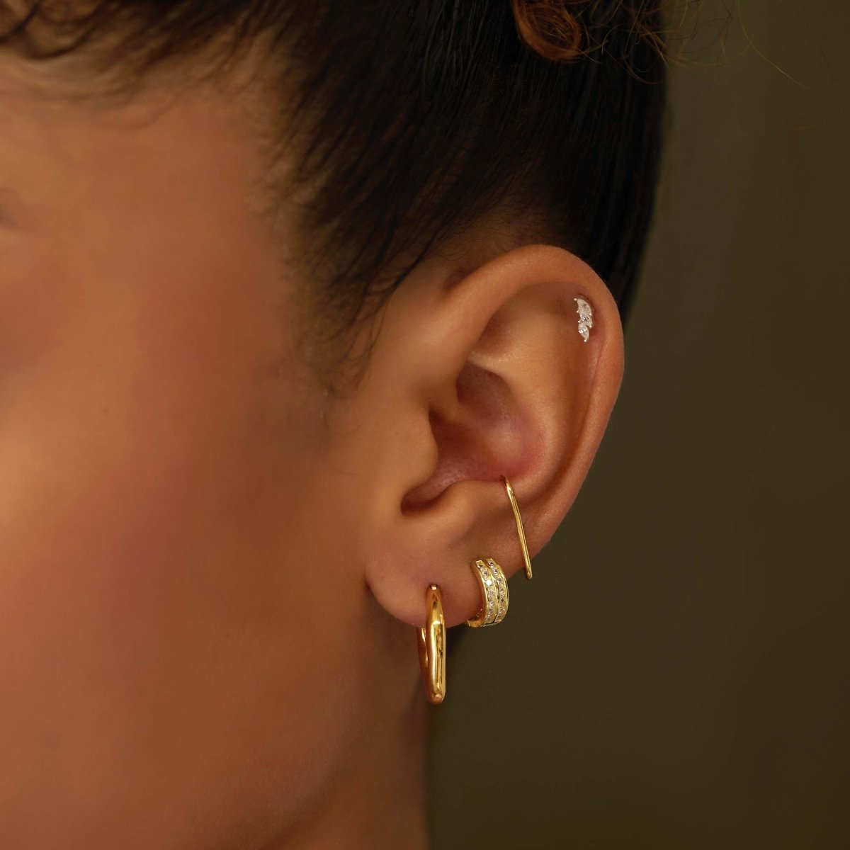 Gold vermeil marquise white zirconia stud styled with silver hoops on a model's ear