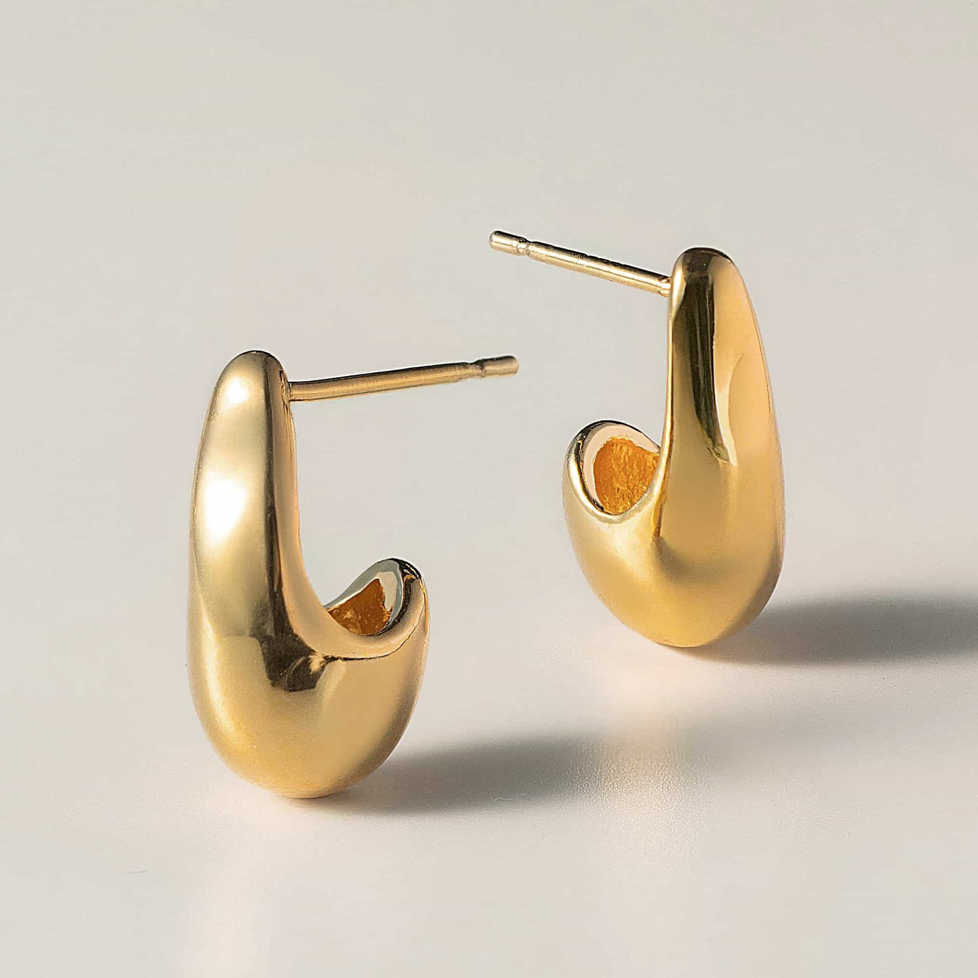 Gold vermeil sculptural teardrop drop earrings, pair shown on a gray background
