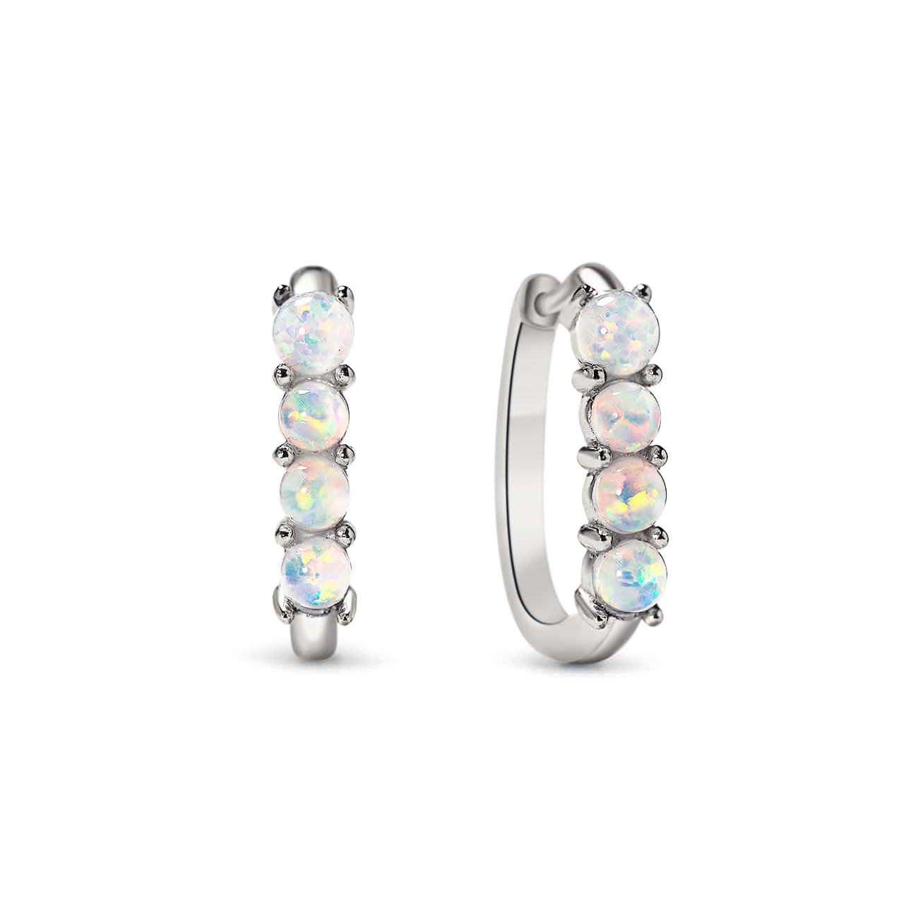 Sterling silver U-shaped huggie hoops set with four white opal stones, on a white background