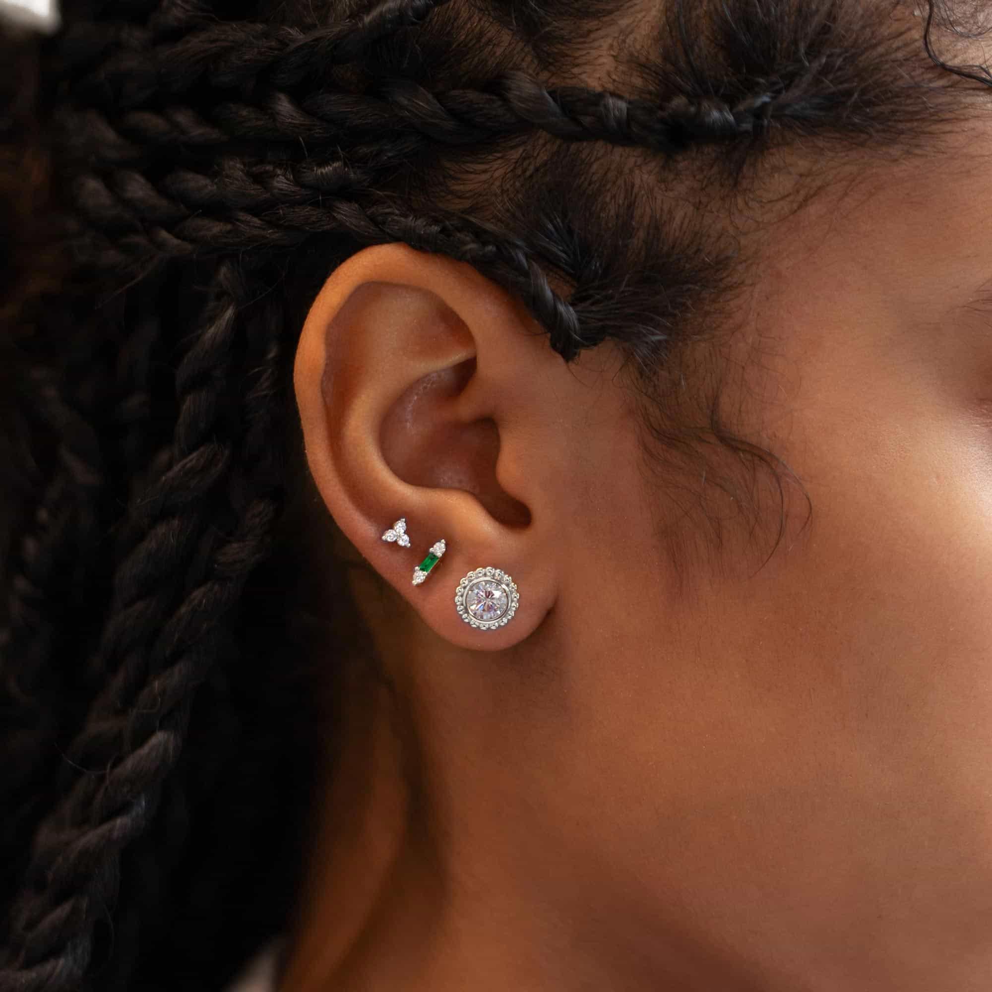 Sterling silver emerald baguette stud shown in a model's silver ear stack