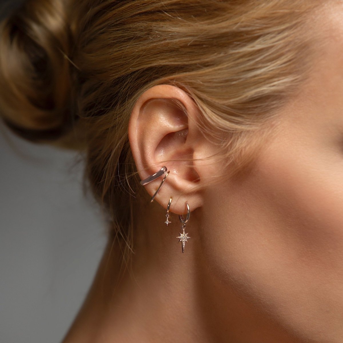 Sterling silver bold suspender ear cuff shown wrapped along a model's outer ear