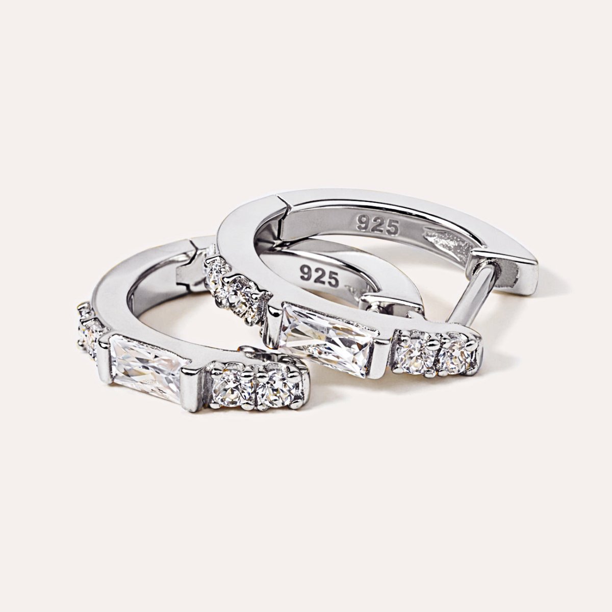 Sterling silver baguette huggie hoops with white zirconia, close-up detail showing 925 stamp