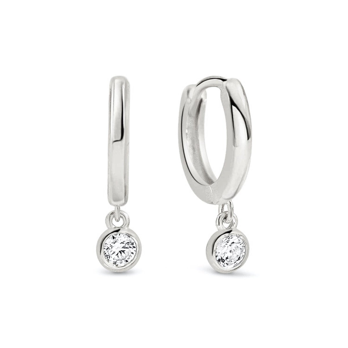 Sterling silver huggie hoops with a dangling round white zirconia drop, on a white background