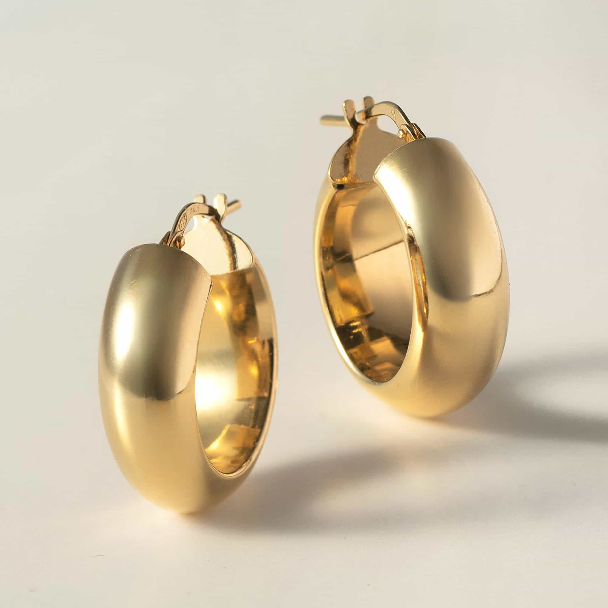 14K gold chunky hoop earrings angled to show width, on a white background