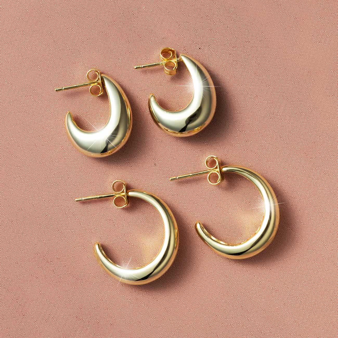 Gold vermeil chunky tapered teardrop hoop earrings, two pairs shown on a pink background