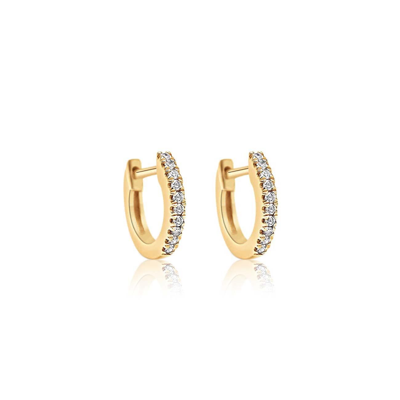 Pair of 14K gold pavé diamond huggie hoops with a hinged closure, on a white background
