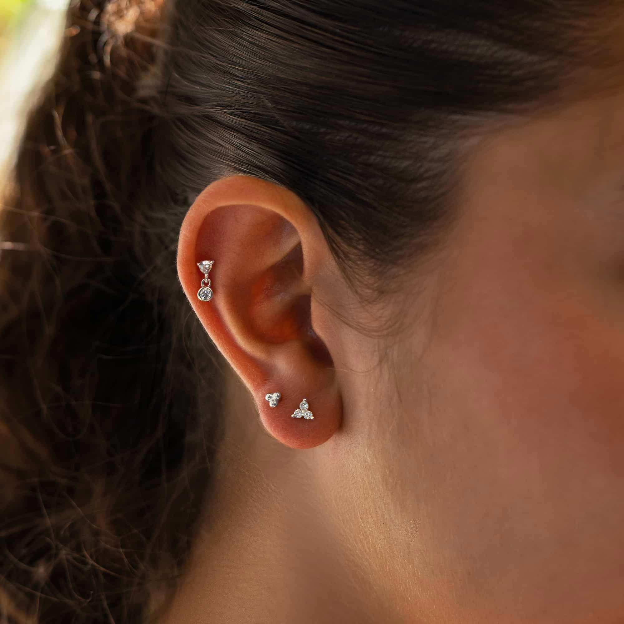 Sterling silver white zirconia trio flat back stud shown on a model's ear lobe