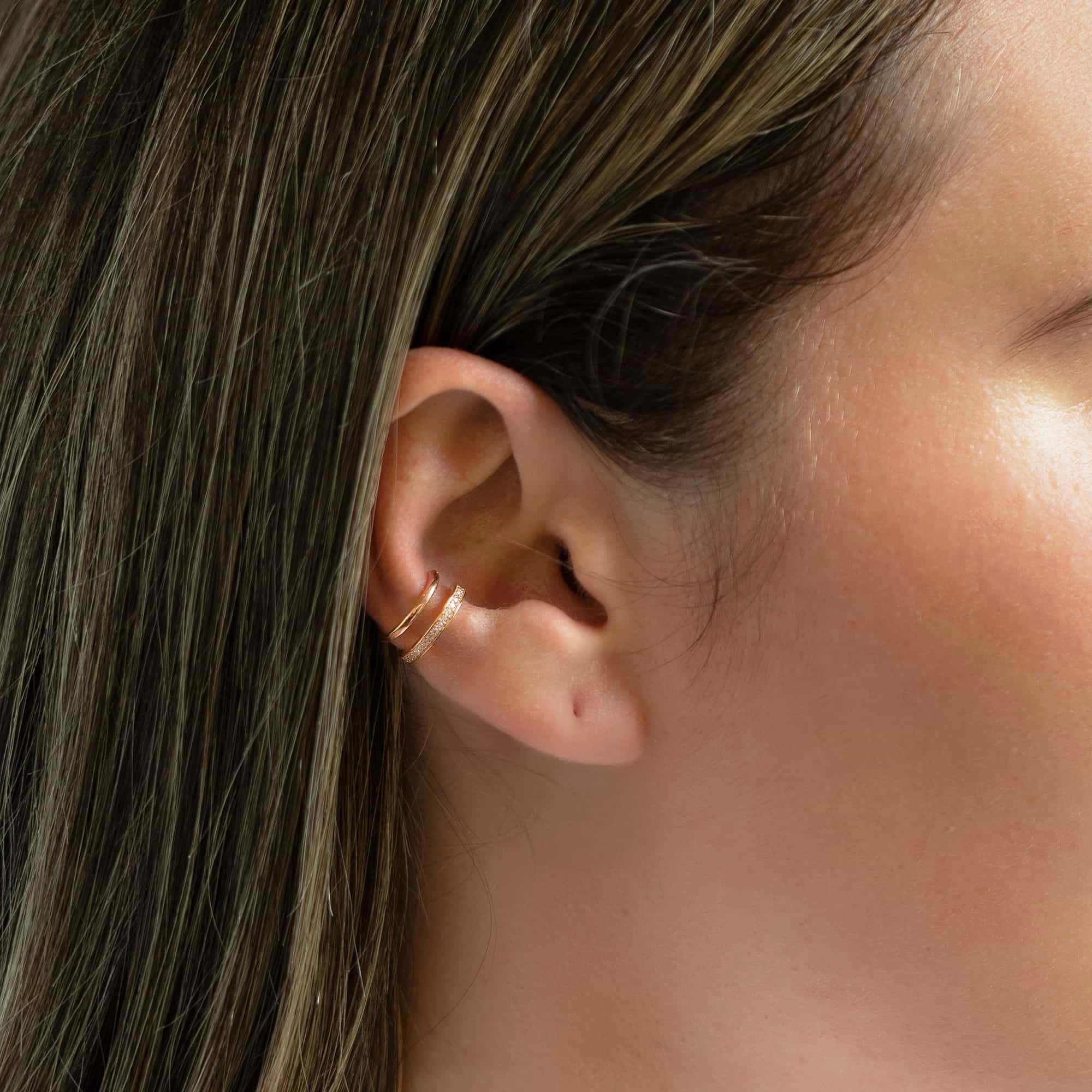 Rose gold vermeil ear cuffs with clear stones, shown on a model's upper ear