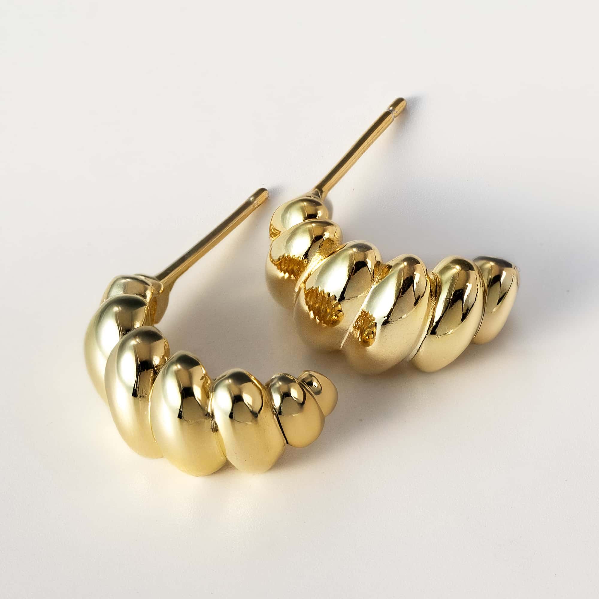 Gold vermeil croissant dome stud earrings shown laid on a white background with posts visible