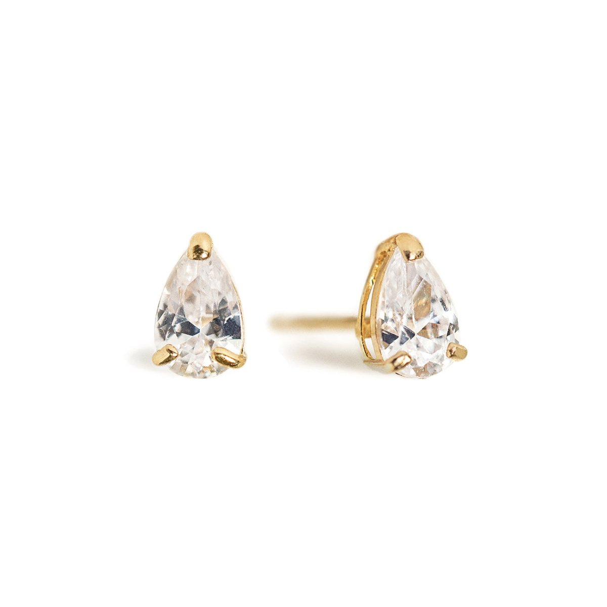 Pair of 14K gold pear-shaped stud earrings with clear prong-set stones, on a white background