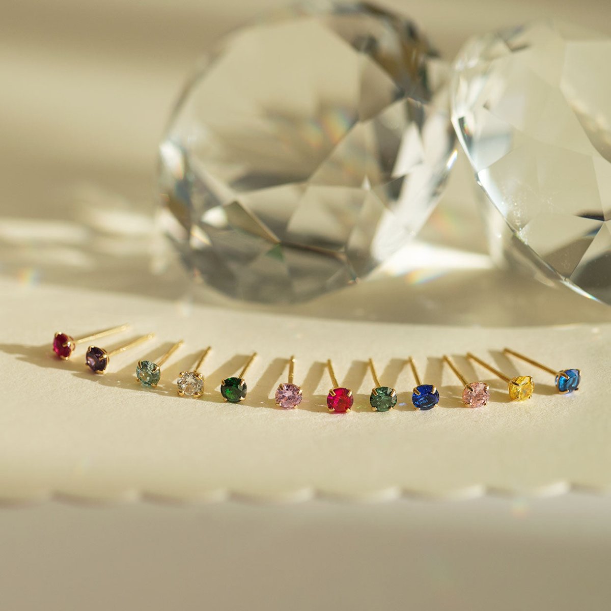 Close-up of earrings featuring 14K Gold Birthstone Tiny Studs