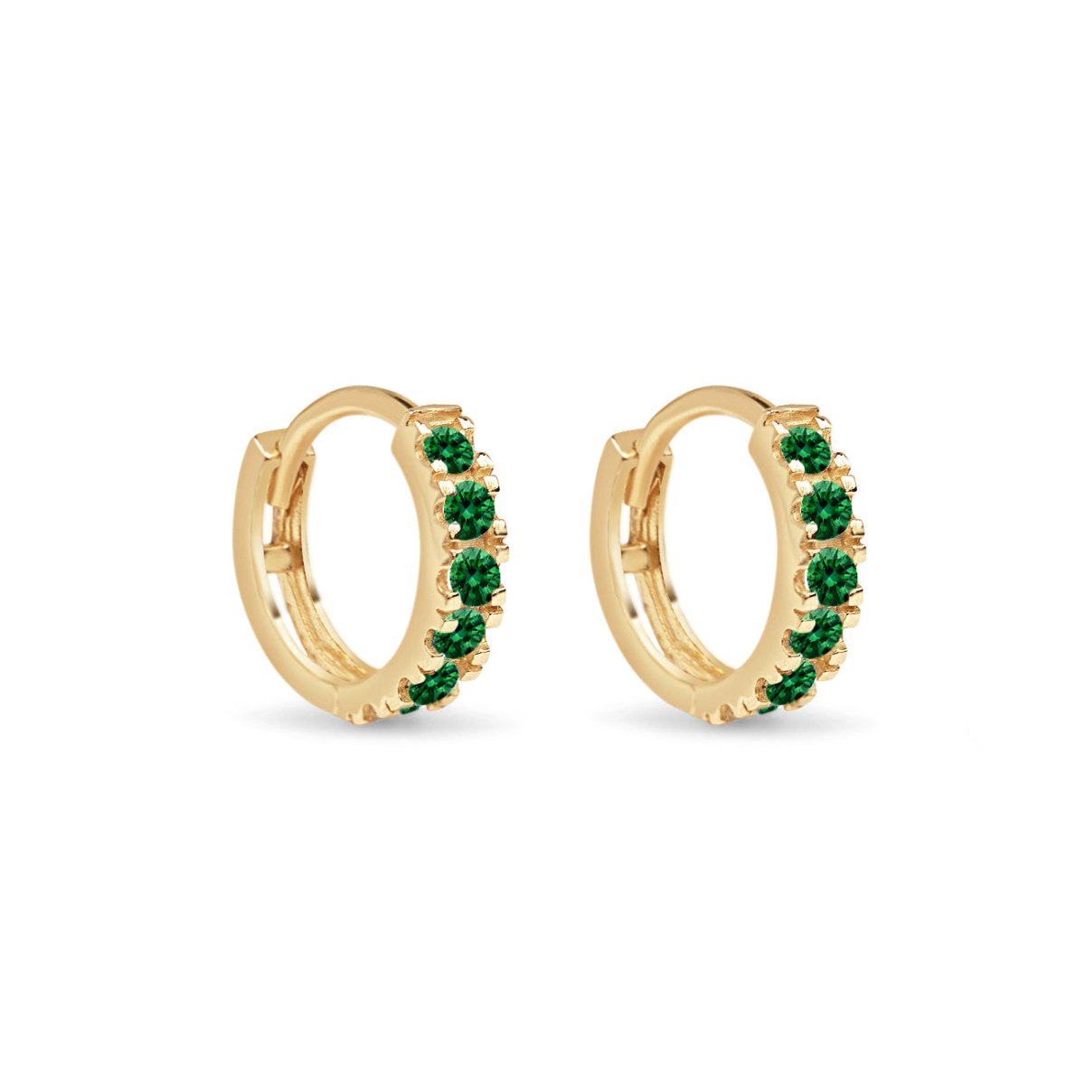 Pair of 14K gold pave huggie hoops set with green emerald stones, on a white background