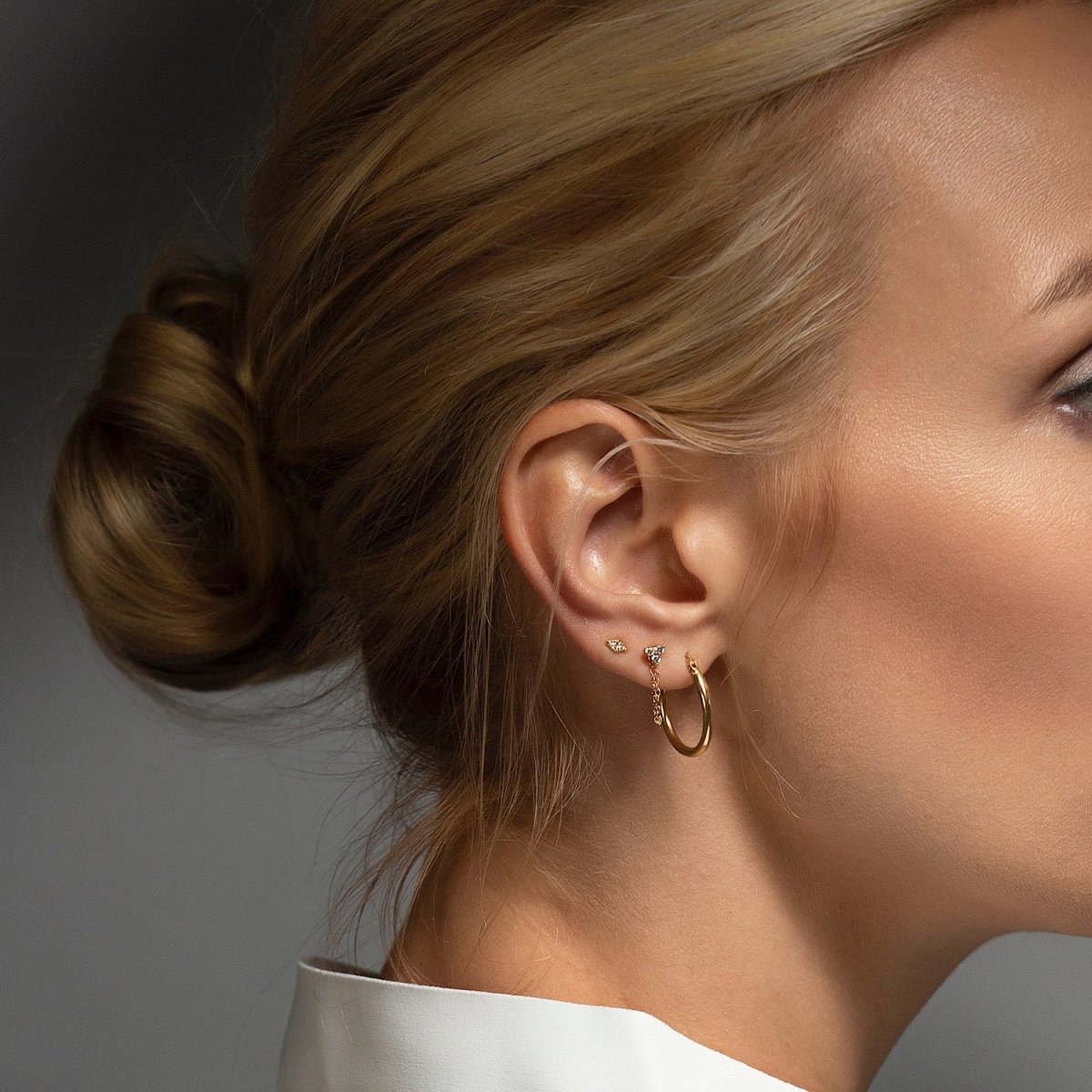 14K gold diamond chain stud earring with a draped chain, shown on a model's ear with a hoop