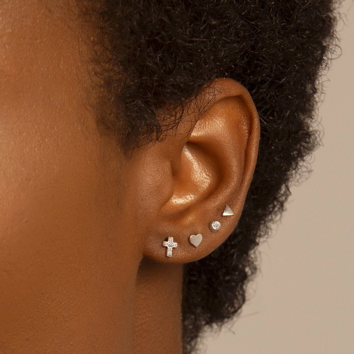 Sterling silver bezel zirconia stud shown on a model's second-piercing lobe in a curated ear stack