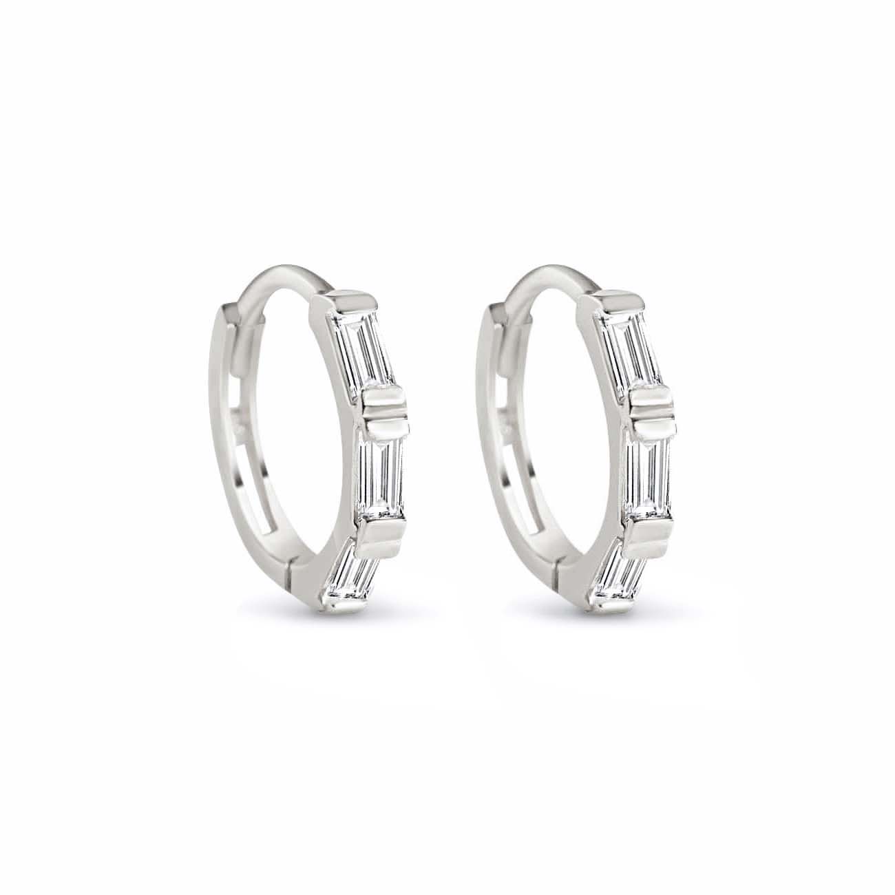 Sterling silver baguette huggie hoops with three clear stones, on a white background